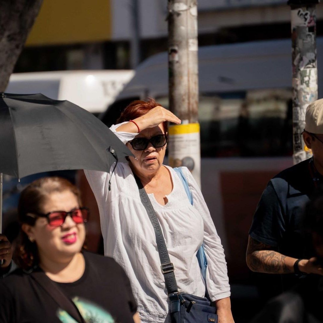 Personas se protegen del sol en Tijuana