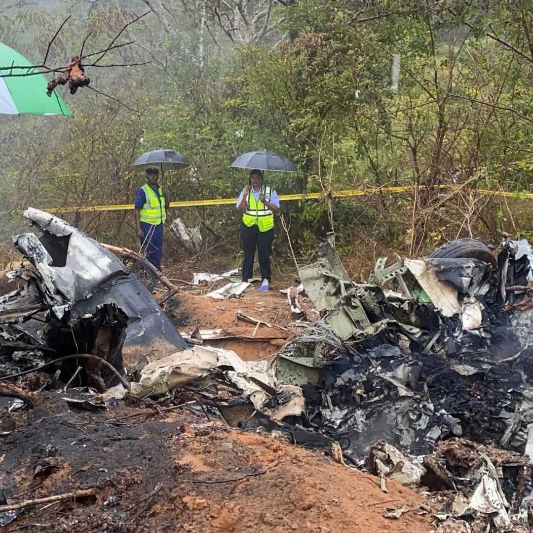 Tres personas caminan en una zona donde estalló un avión.