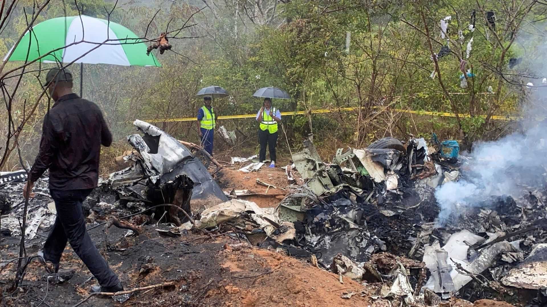 Tres personas caminan en una zona donde estalló un avión.