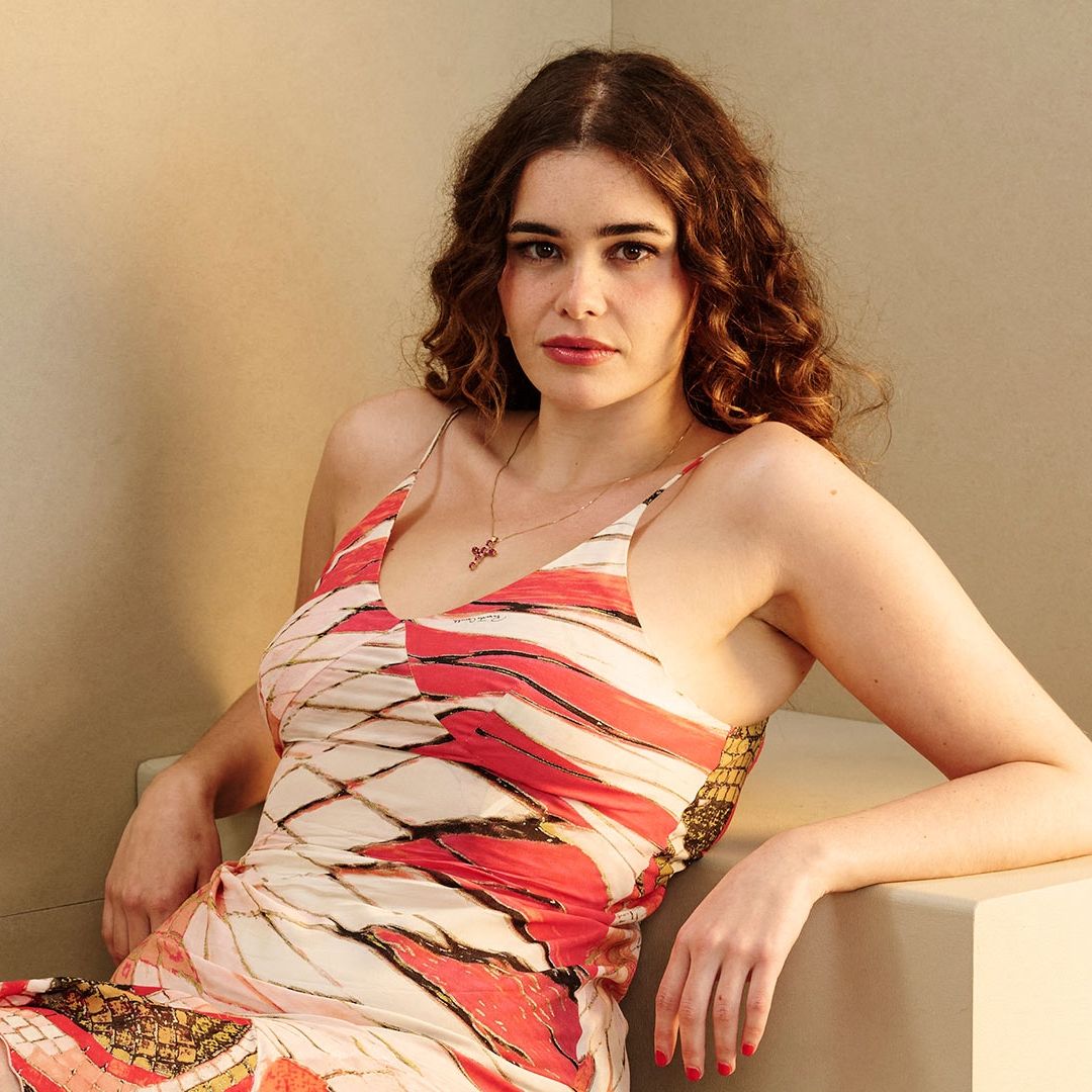 Barbie Ferreira recargada en un cubo con un fondo color beige.
