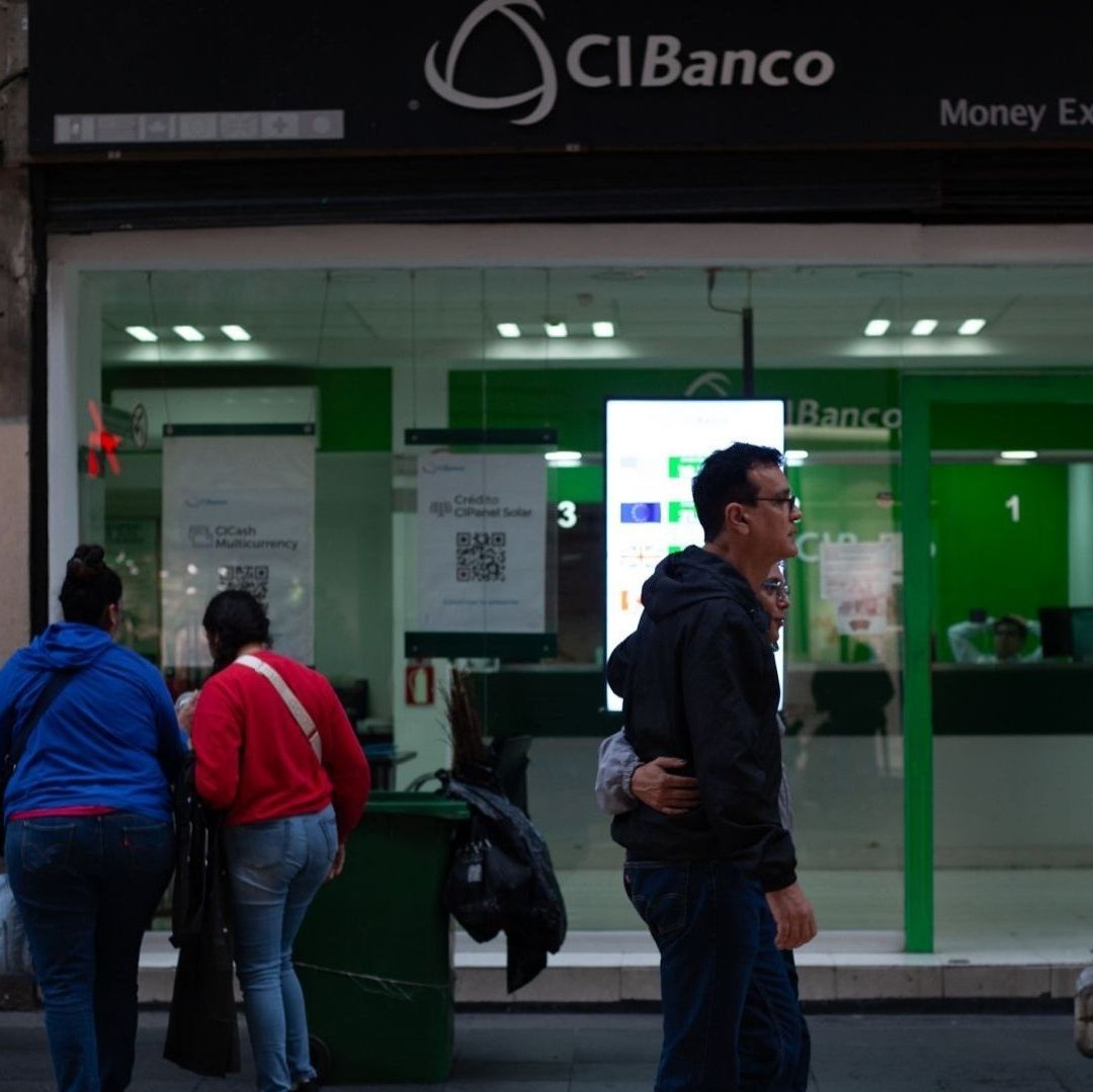 Varias personas afuera de un banco.