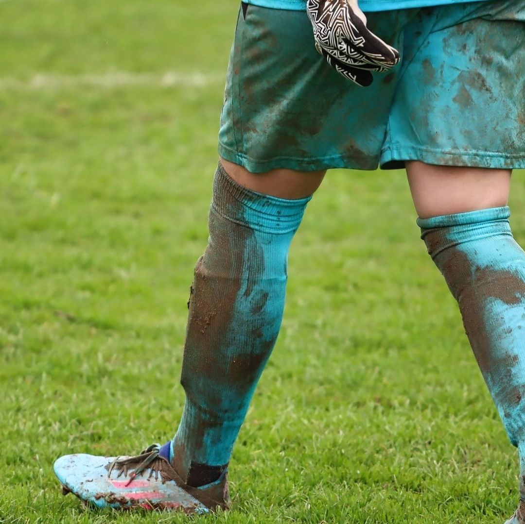 Un hombre con uniforme de futbol sucio en una cancha.