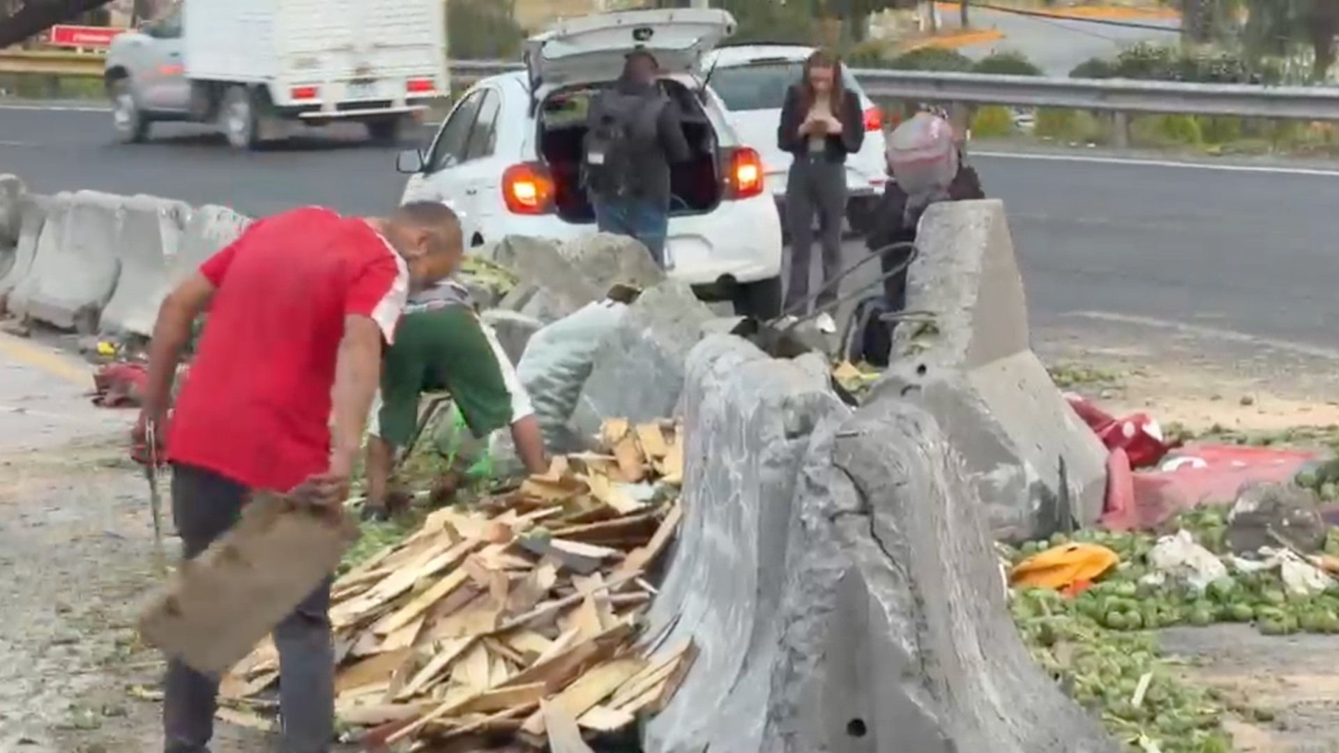 Personas levantan verdura luego de volcadura de camión