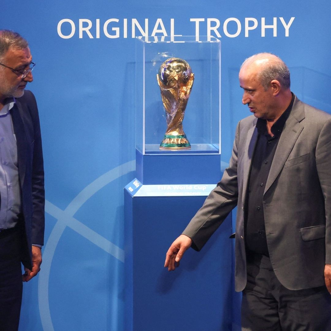 El presidente de la Federación Iraní de Fútbol, Mehdi Taj (derecha) posa junto al trofeo de la Copa Mundial de la FIFA, en Teherán, Irán. Foto: Reuters