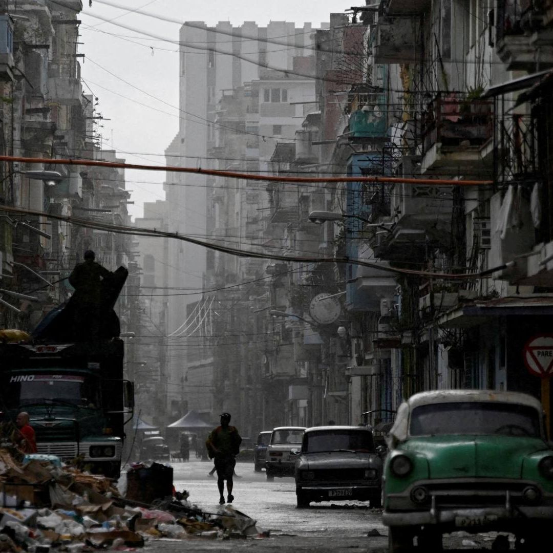 Hombre camina bajo la lluvia mientras Cuba restablecía red eléctrica el 17 de marzo de 2026. Foto: Reuters | Archivo