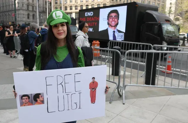 Manifestante con una pancarta en apoyo a Luigi Mangione