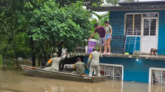 Elemento de Fuerzas Armadas auxilian a personas atrapadas en su casa por inundación.