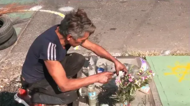 Adolfo coloca veladoras en el sitio donde fue atropellado José, el joven ciclista