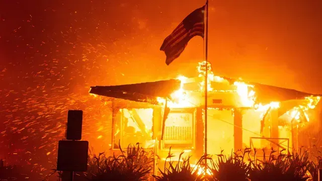 Una bandera estadounidense ondea mientras el fuego consume una estructura mientras el incendio Palisades arde en Los Ángeles, el 7 de enero de 2025. Foto: Reuters