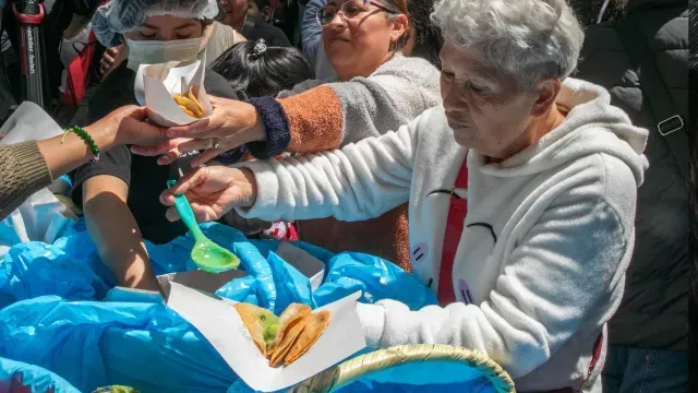 Una señora se prepara sus tacos de canasta con salsa verde. Foto: Cuartoscuro