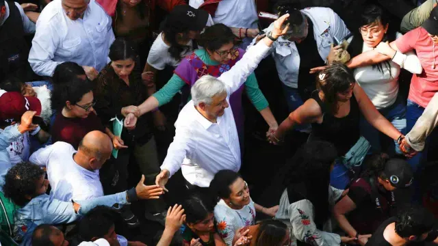 AMLO y Sheinbaum caminan ante una multitud en la marcha en CDMX