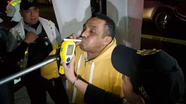 Un hombre sopla una prueba de alcoholemia.