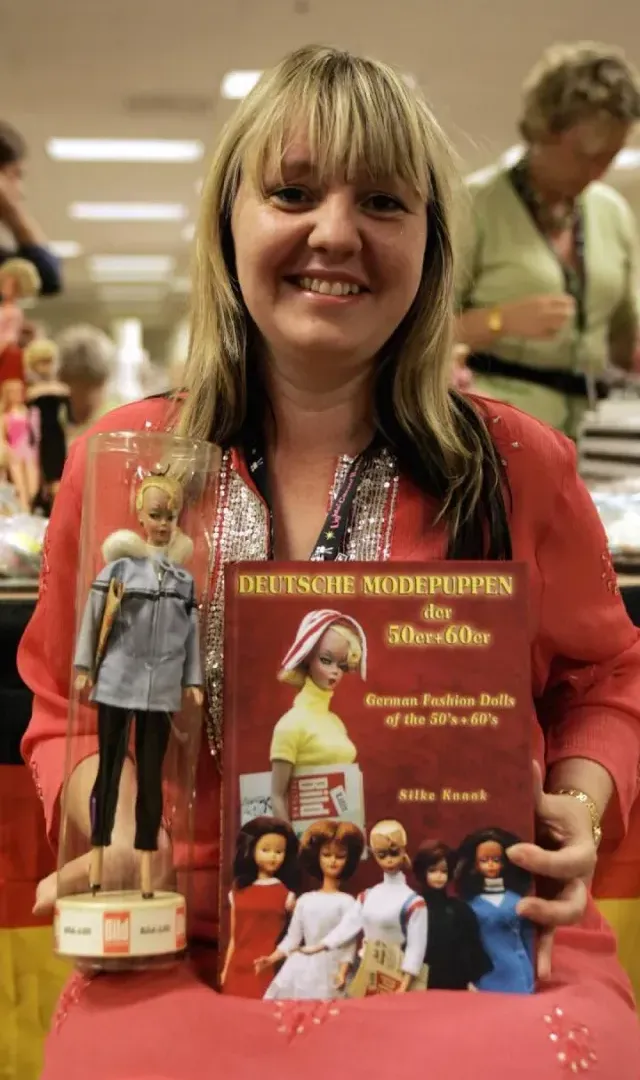 La coleccionista de muñecas Silke Knaak, de Hamburgo, Alemania, posa con su libro y una muñeca Lili original