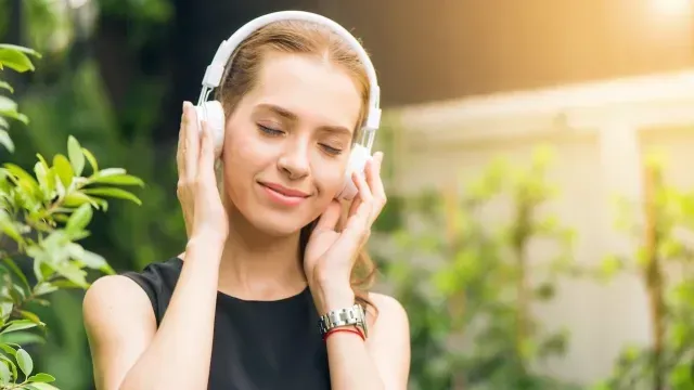 Mujer escucha música en unos audífonos