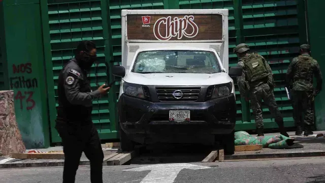 Normalistas impactan camioneta en puerta principal del cuartel militar