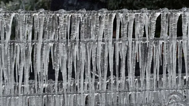 Trozos de hielo cuelgan de una cerca.