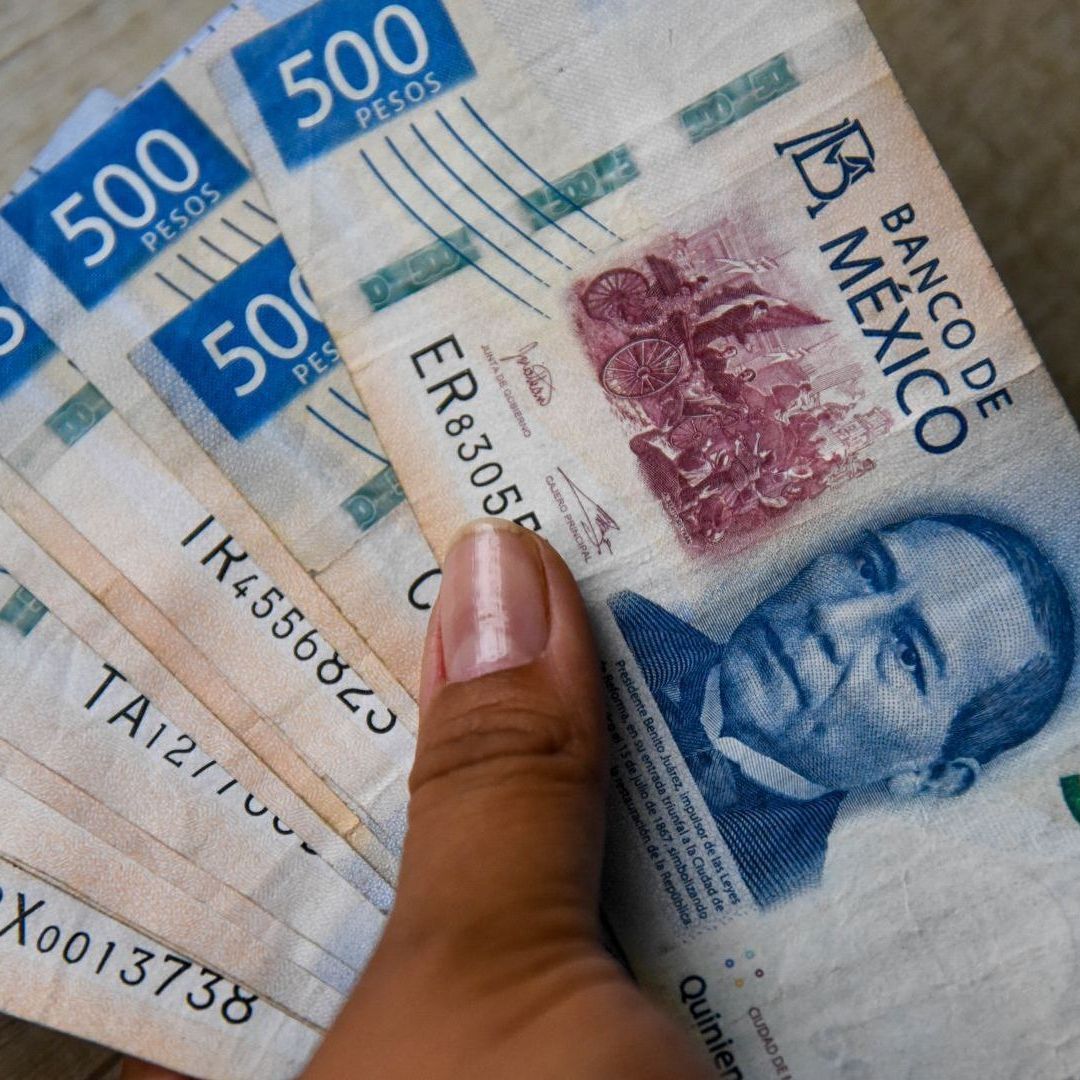 Persona sostiene Billetes de 500. Utilidades pagan impuestos 2026