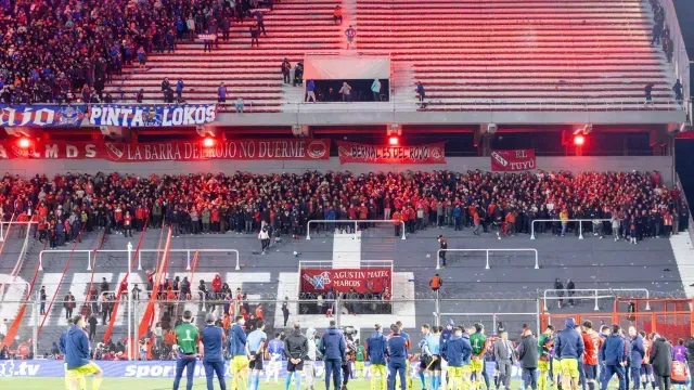 Jugadores ven desde la cancha los problemas en las gradas del estadio Libertadores de América. Foto: AFP