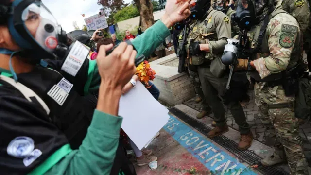 Agentes federales, incluyendo miembros del Departamento de Seguridad Nacional, la Patrulla Fronteriza y la policía, intentan contener a los manifestantes frente a una instalación del Servicio de Inmigración y Control de Aduanas (ICE) en el centro de Portland, Oregón. Foto: AFP