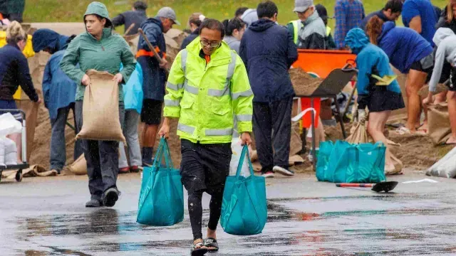 Personas llenan sacos de arena en preparación para la llegada del ciclón Gabrielle
