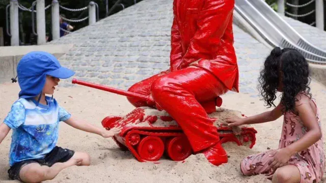Niños juegan con la estatua de Vladimir Putin