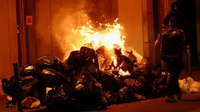 Una persona junto a un fuego encendido durante la manifestación en París.Foto: Reuters