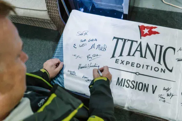 Hamish Harding firma un baúl de la expedición