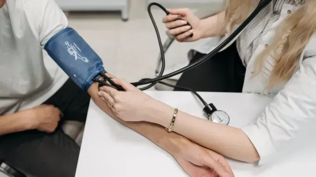 Médica revisa la presión sanguínea de paciente