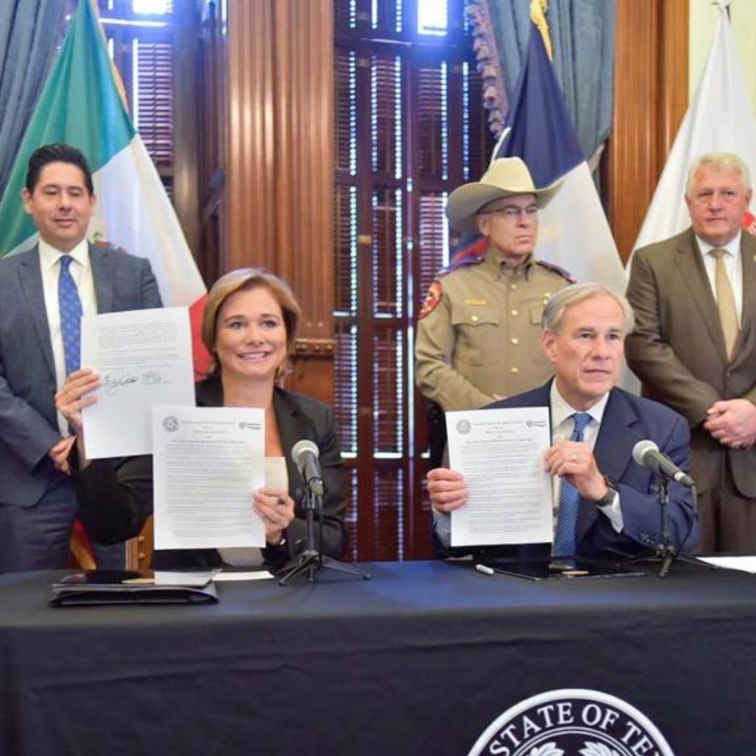 María Eugenia Campos y Greg Abbott muestran documento