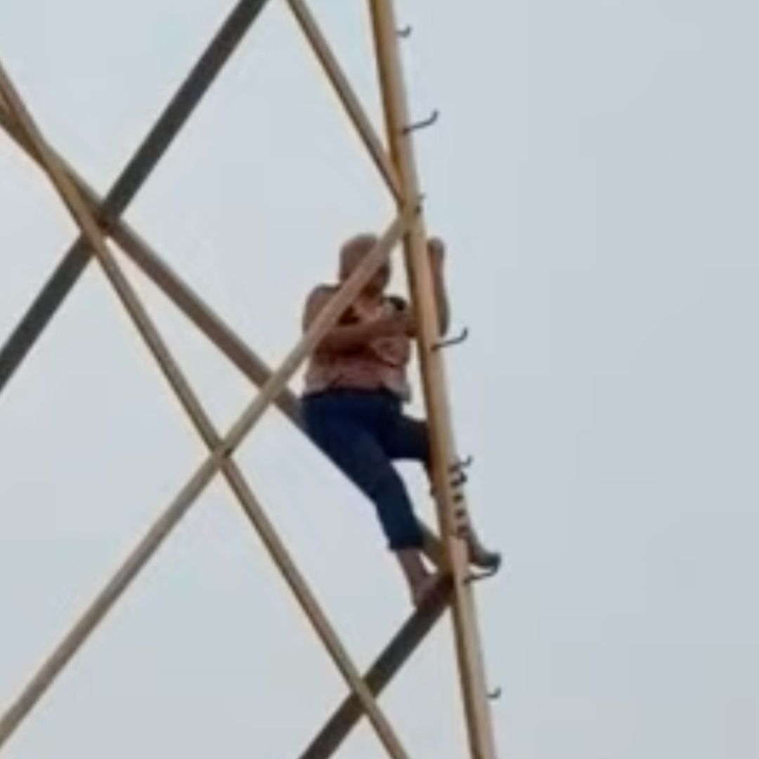 Mujer sube a torre eléctirca