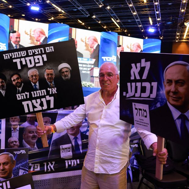 Un simpatizante reacciona ante las encuestas a pie de urna sosteniendo carteles que muestran al primer ministro israelí. Foto: Reuters