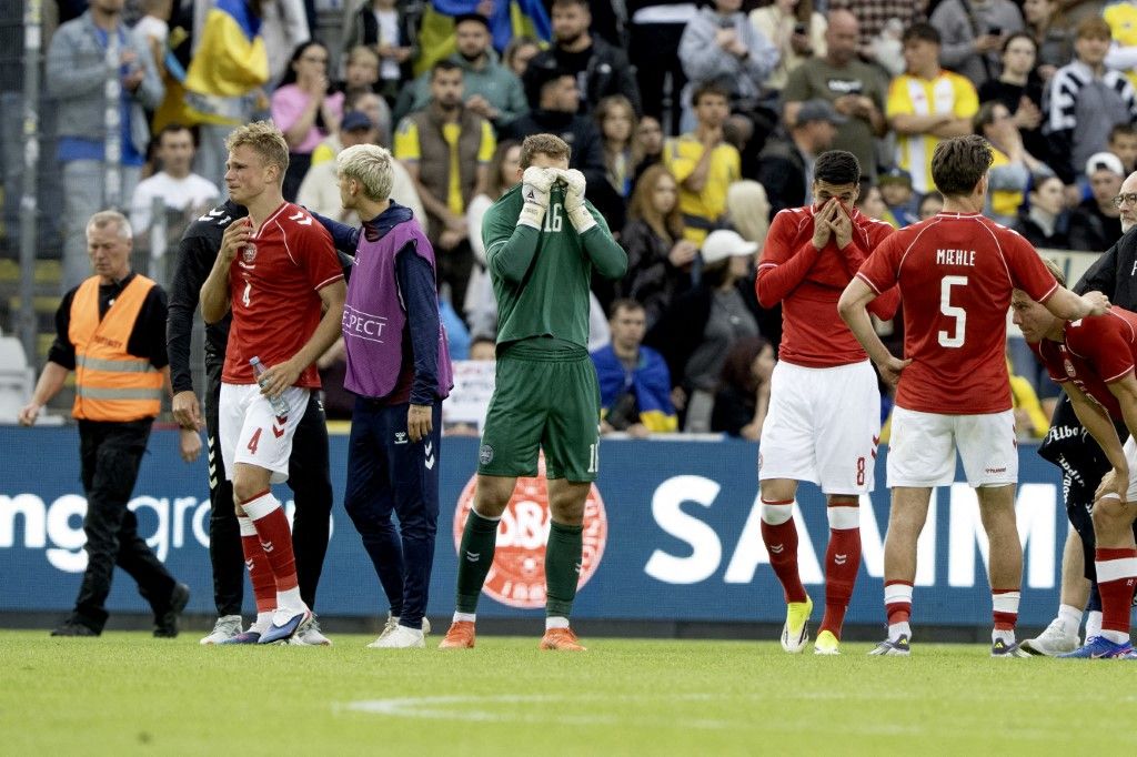 Los daneses Lukas Hoegsberg, Albert Groenbaek, el portero Mads Hermansen, Adam Daghim, Joakim Maehle y Rasmus Hoejlund reaccionan después de que Christian Eriksen se derrumba en el campo durante el partido de fútbol. Foto: AFP