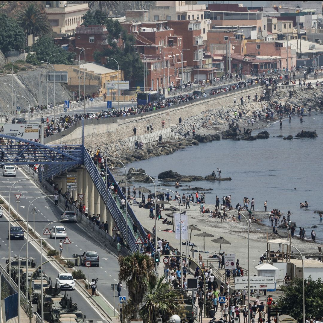 Una fotografía tomada en las afueras de la ciudad marroquí de Fnideq, en la frontera entre Marruecos y España, muestra a migrantes caminando por la costa de Ceuta tras cruzar al enclave español, el 31 de julio de 2026.. Foto: AFP