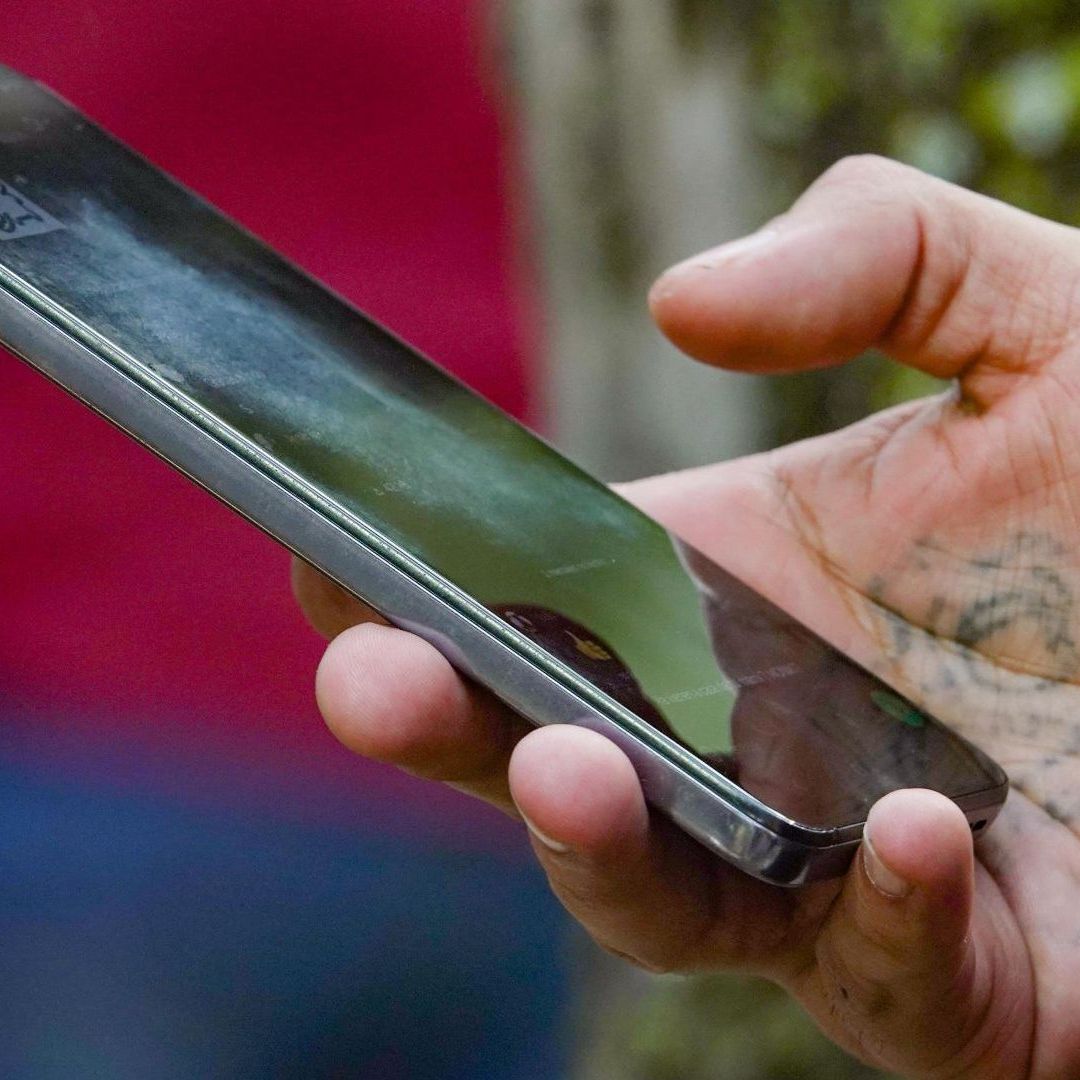 Mano sostiene celular por Registro de Celulares 2026. Alta de Datos Biométricos