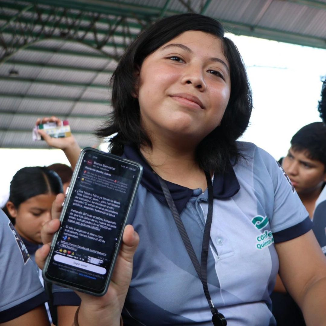 Estudiante sostiene celular. Dónde suspendieron Asamblea Beca Bienestar 2026.