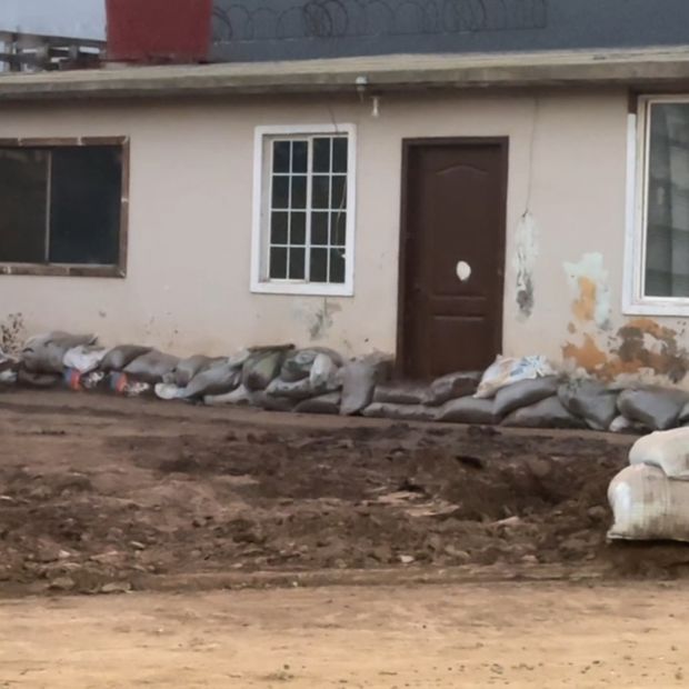 Sacos de arena colocados de forma improvisada en la entrada de una vivienda para frenar el agua