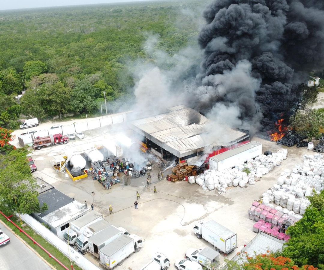 Bomberos atienden fuerte incendio en almacén de aceites en Cancún.