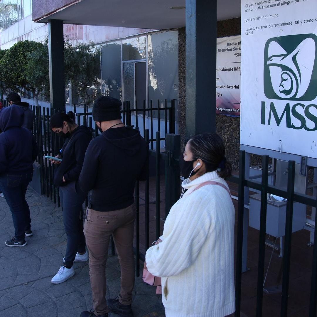 Personas hacen fila en IMSS. Trámite de Número de Seguridad Social, IMSS