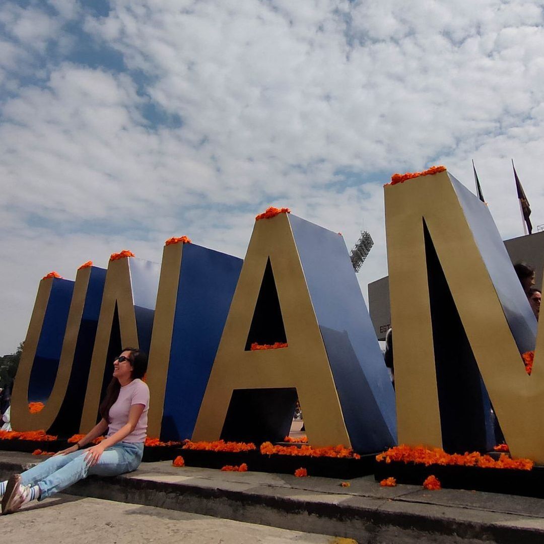 Mujer se retrata frente a tipografías de la UNAM. Resultados pase Reglamentado UNAM 2026.
