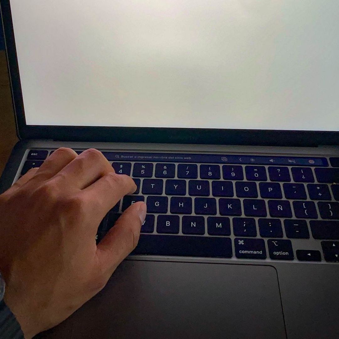 Mano escribe sobre teclado de laptop. Venta en Línea en México
