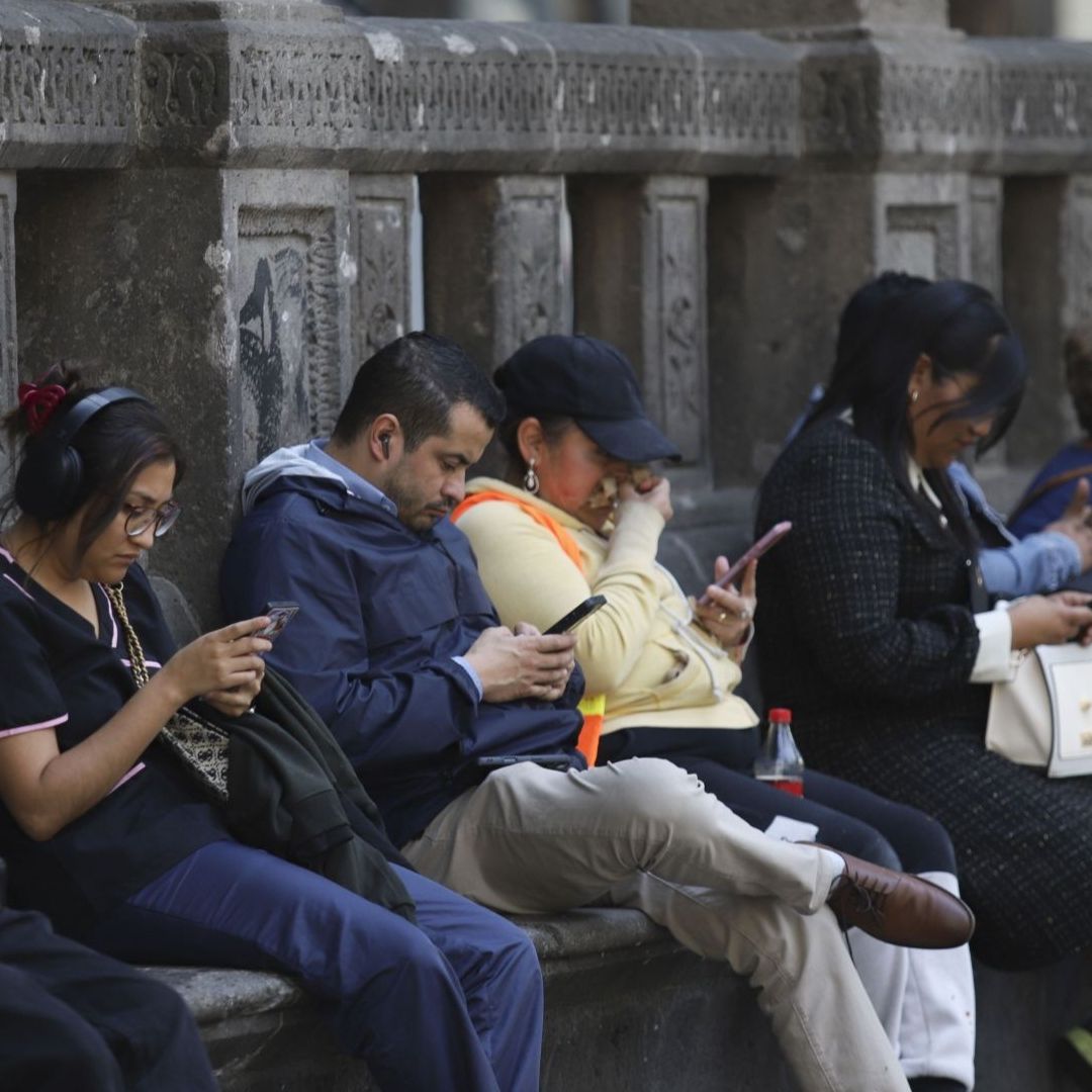 Personas utilizando teléfono móvil