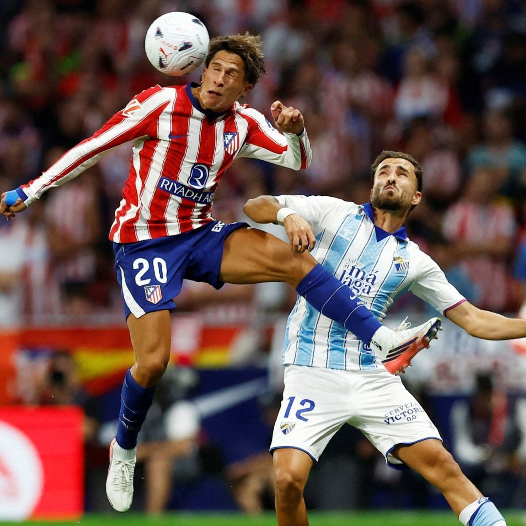 Giuliano Simeone cabecea la pelota ante José Salinas en el partido del Atlético de Madrid contra el Málaga.