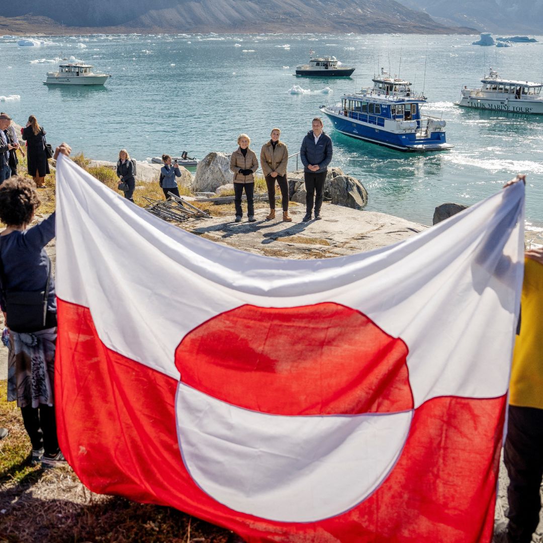 Ciudadanos sostienen la bandera de Groenlandia durante la visita de funcionarios europeos