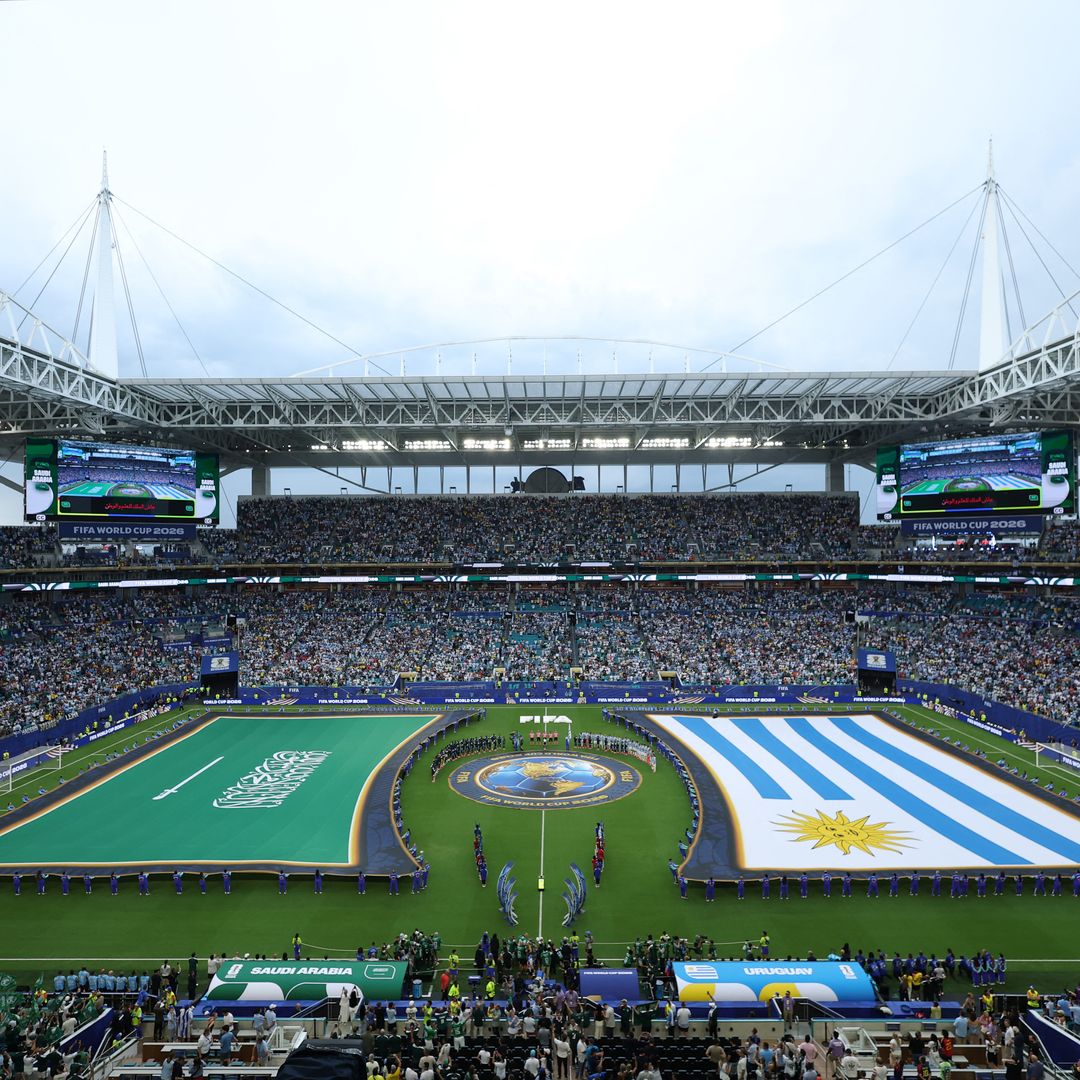 Voluntarios sostienen las banderas durante el protocolo de los himnos en el Mundial 2026; la insignia de Arabia Saudita no tuvo contacto con el terreno de juego.