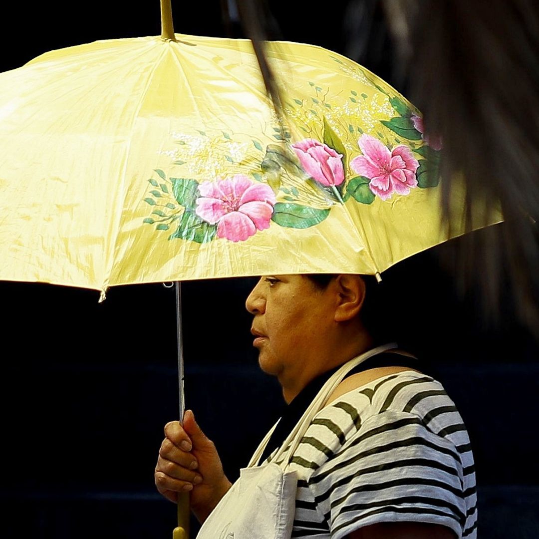 Una mujer se protege del sol con una sombrilla, ante altas temperaturas en CDMX en mayo 2026. Foto: Cuartoscuro | Archivo
