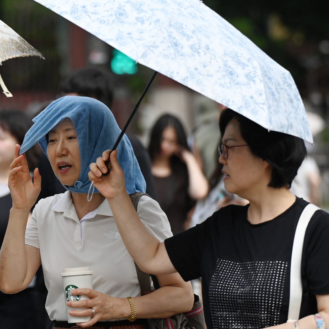 Personas se cubren del intenso calor en Corea del Sur