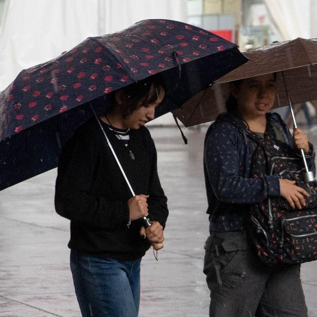 Mujeres se cubren de la lluvia en el Zócalo de la CDMX el 9 de octubre 2026. Foto: Cuartoscuro | Archivo