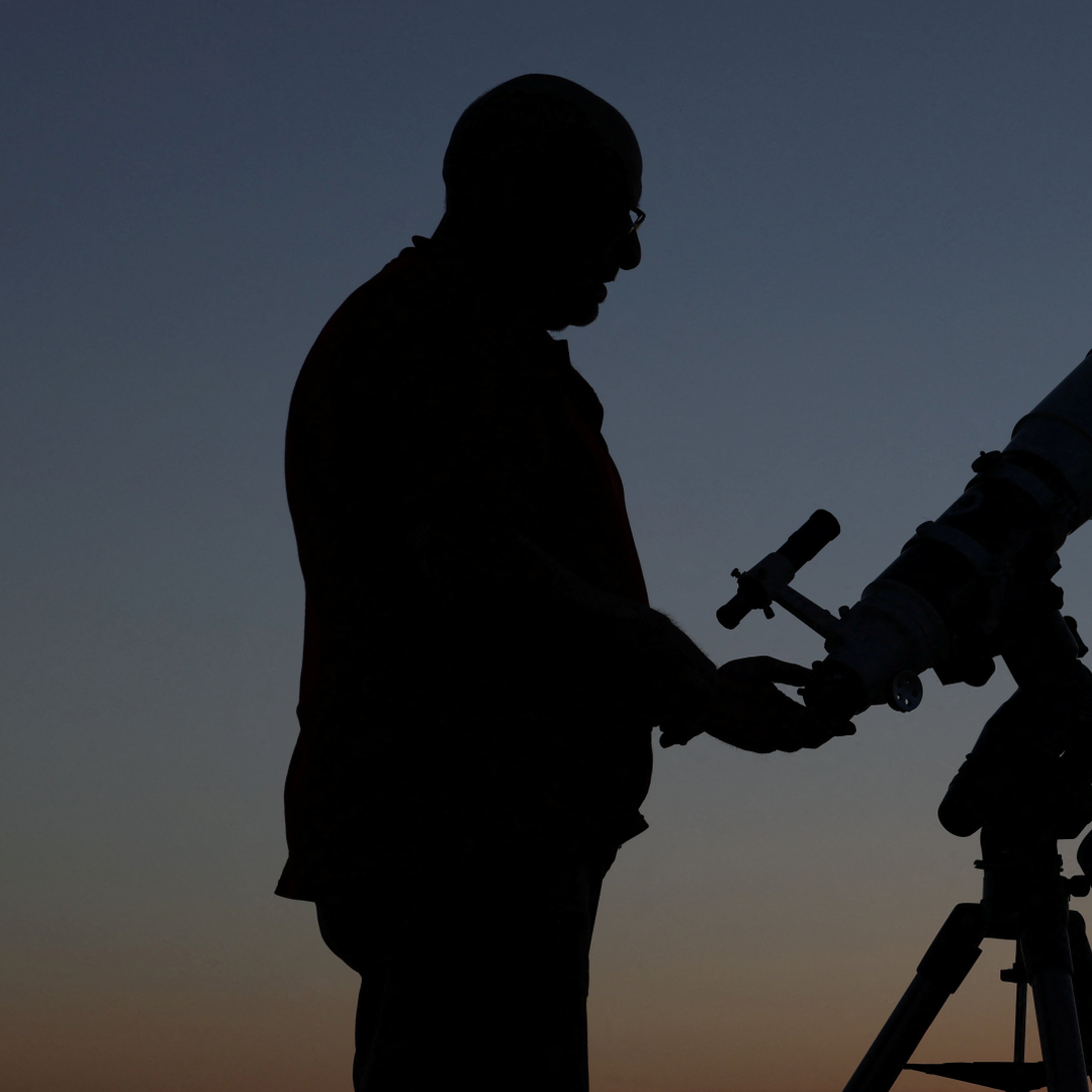 Persona mira el cielo con un telescopio