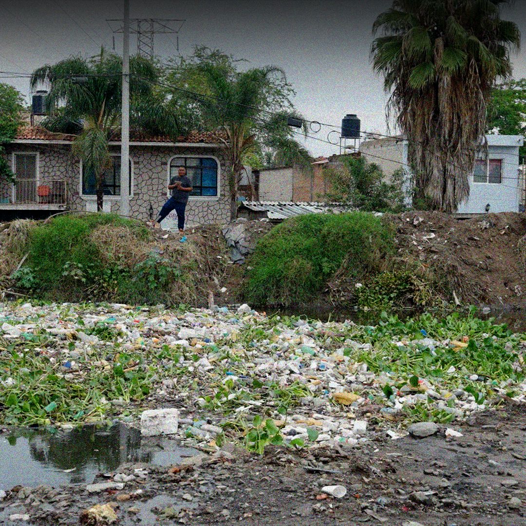 Una persona observando el canal contaminado.