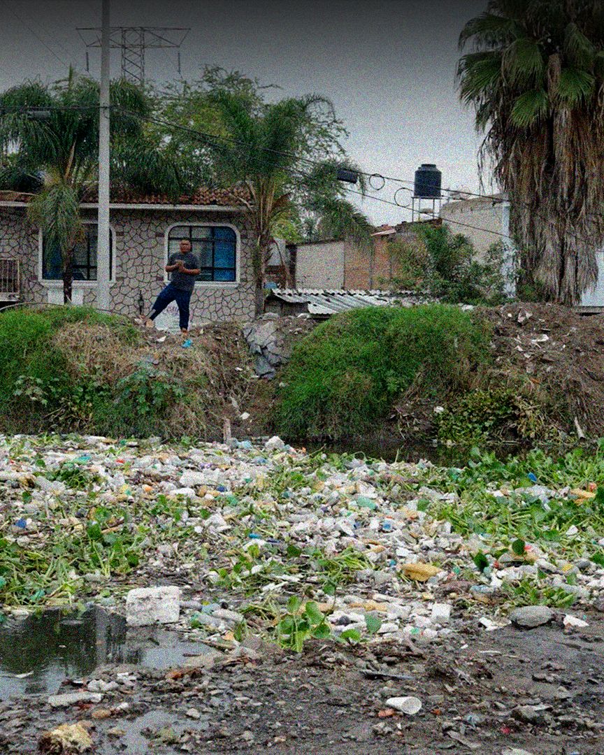 Una persona observando el canal contaminado.